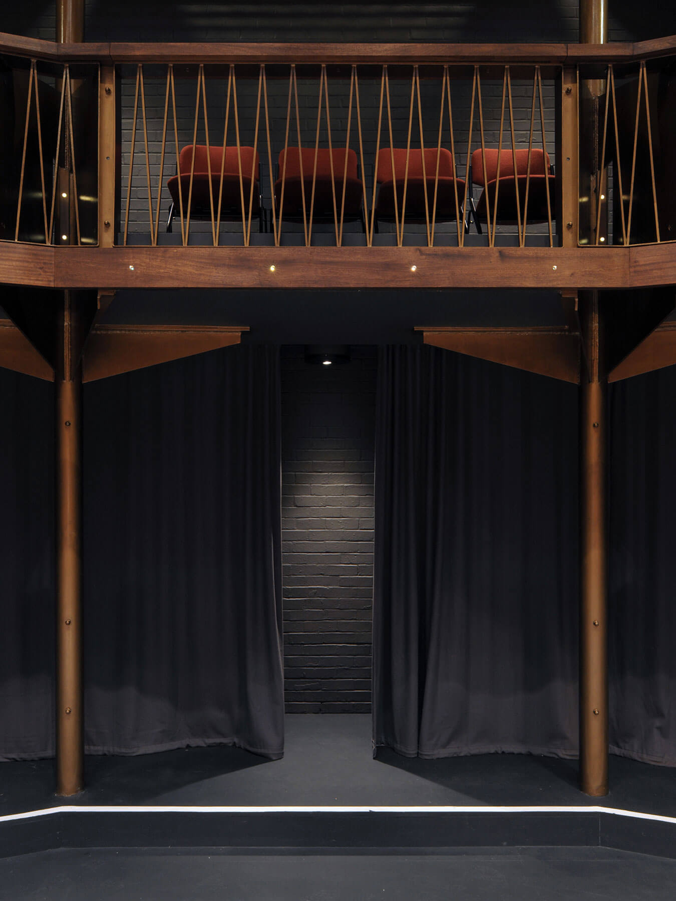 A dark but rich material palette: hardwood, bronze metallic paint, dark painted brickwork